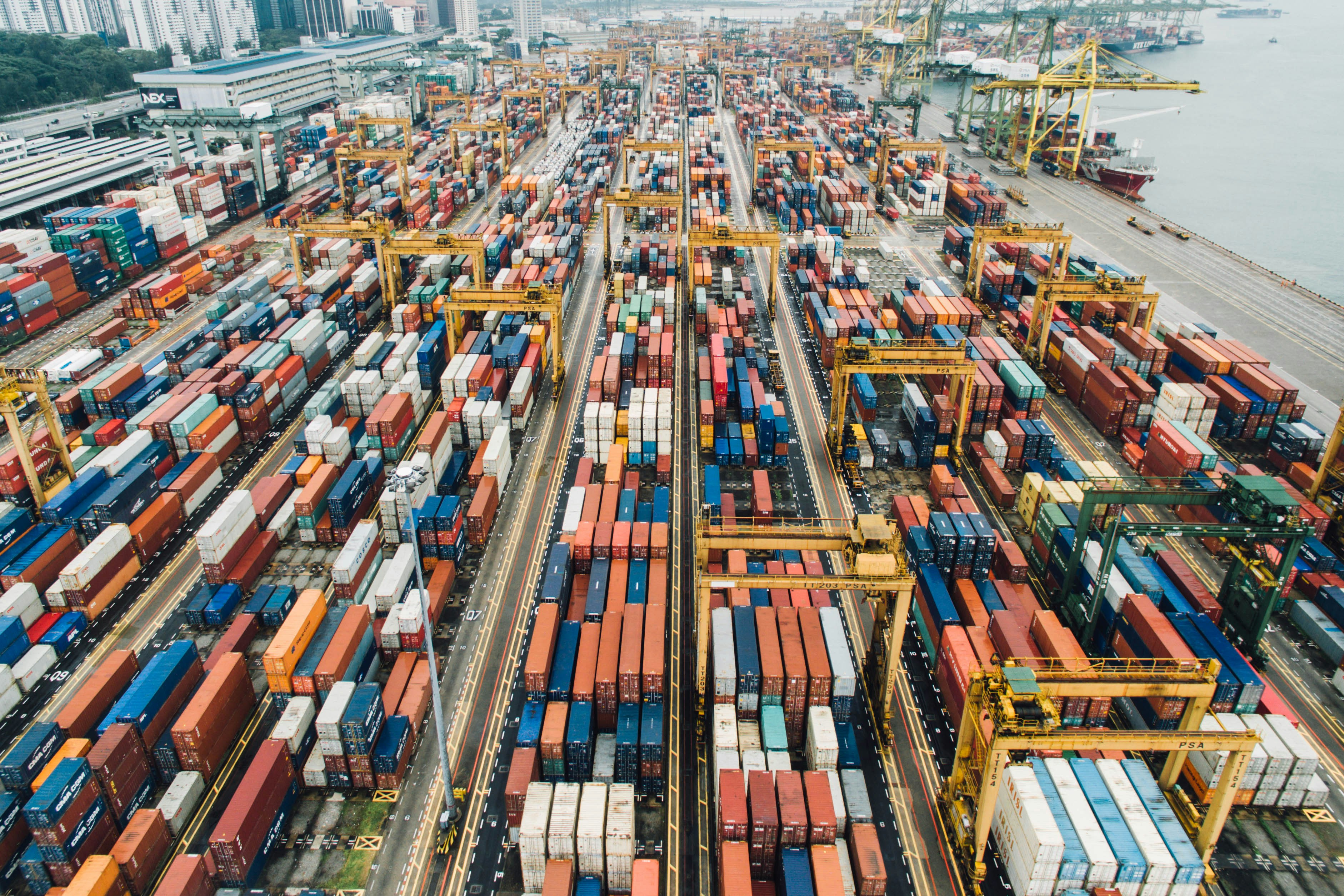 A coloured picture showing a harbour with masses of containers